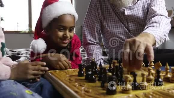 可爱的小女孩戴着圣诞帽看象棋比赛