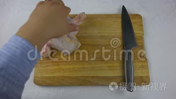 厨师用刀子把木板上的鸡腿切开视频
