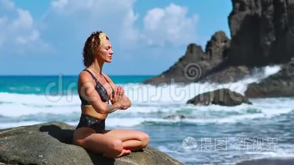 瑟琳冥想瑜伽。 布鲁内特旅游妇女在风景优美的普拉亚达马林哈上的海角上沉思