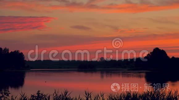 浪漫的猩红日落景色的全景与倒影的天空