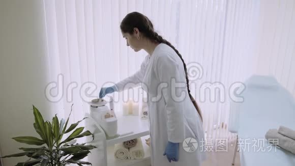 在一家美容美发沙龙的美容师检查打蜡和加糖，开始脱毛。