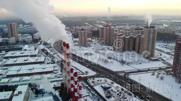 工业区的鸟瞰图，有大的红色和白色管道和白色烟雾。 烟是从工厂的管道中倒入的