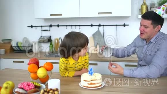 非常可爱的男孩用蛋糕和快乐的父亲庆祝他的生日。 父亲节。 四年生日快乐。 小男孩