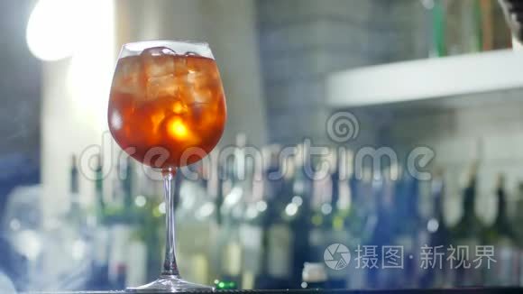 酒保在酒精饮料中加入柠檬片和塑料吸管，在酒杯特写中加入冰块，在没有聚焦的地方加入雾