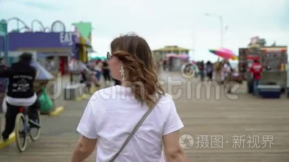 在圣莫尼卡码头散步的年轻女子视频