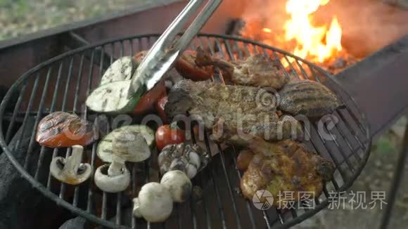 主厨用火钳将肉与迷迭香枝和烤菜搭配，将熟食从