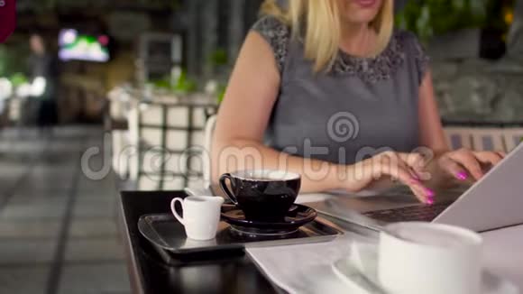 一位穿着灰色衣服的成年女性，在餐厅里坐在桌上，打字视频的预览图