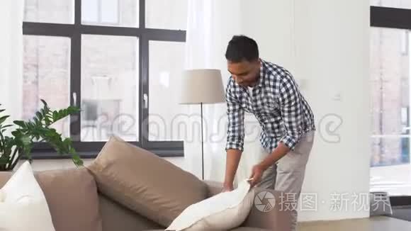印度男人在家里布置沙发靠垫视频