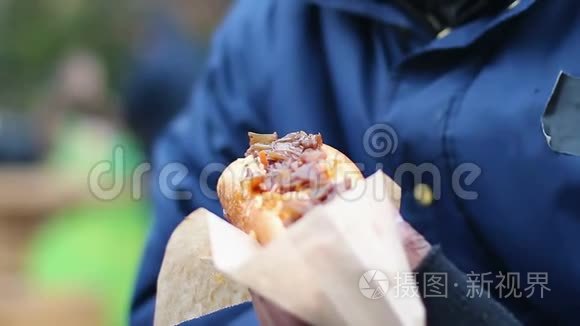 男性垃圾食品成瘾者咬食油腻的热狗，不健康的饮食习惯