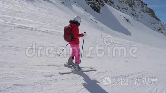 在运动侧景中，女子滑雪者滑下山的度假村