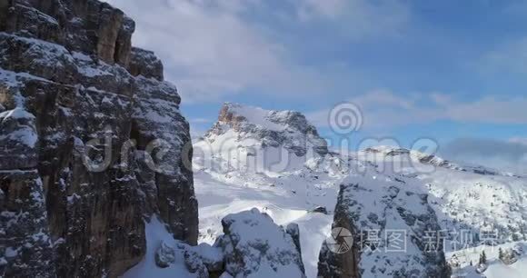 向前空中通过雄伟的Cinque Torri岩石坐骑显示滑雪轨道。 晴天，天空多云。 冬季白云