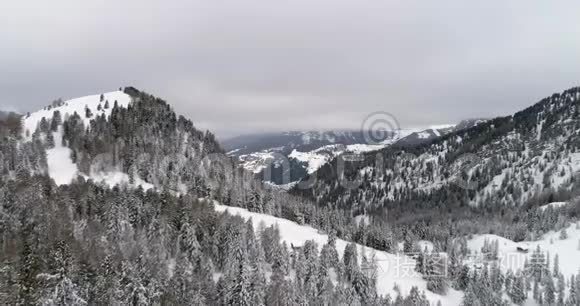 从空中飞向白雪皑皑的森林和山丘。 多云坏阴多雾天气.. 意大利阿尔卑斯山冬季白云石