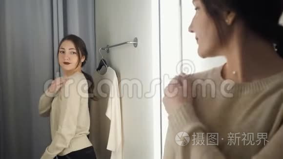 漂亮的女人在试衣间测量衣服