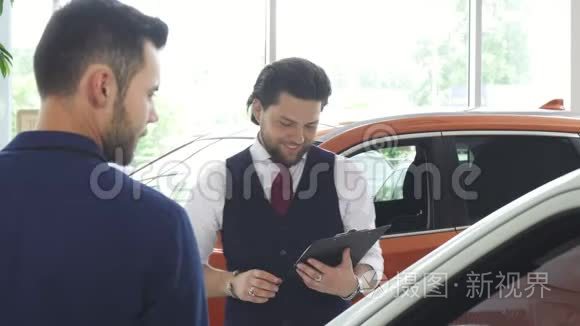 英俊的男性汽车经销商与他的男性顾客交谈