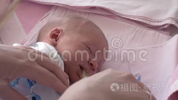 妈妈给昏昏欲睡的新生婴儿盛水视频