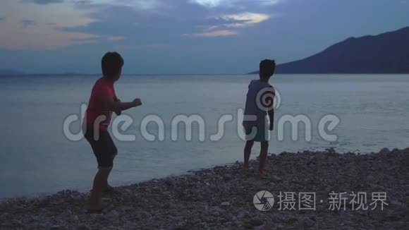 两个男孩日落时在海上跳过石头视频