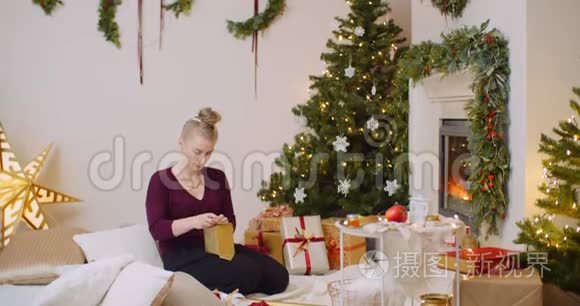 妇女在家中用壁炉包装圣诞礼物视频