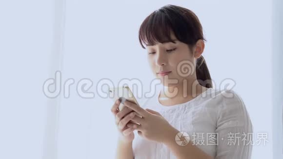 美丽的肖像年轻的亚洲女人微笑着站着看着智能手机阅读社交网络