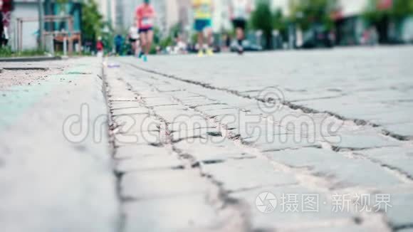 运动员沿着铺路石、城市马拉松、跑步者`腿部特写、体育比赛