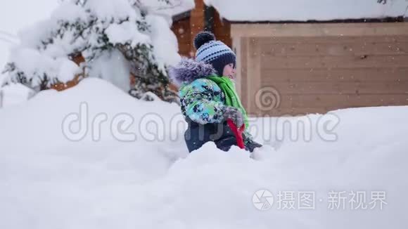 一个小孩在冬天的公园里玩雪.. 孩子拿着铲子，公园里有很多雪。 有趣的游戏