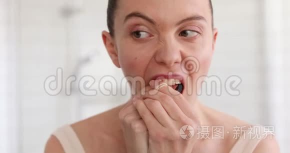卫生间用牙线清洁牙齿的女人视频