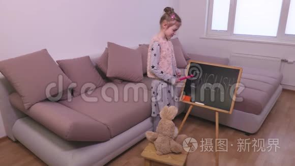 小女孩在黑板附近教兔玩具