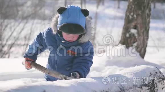 一个小孩在冬季公园里玩耍，笑嘻嘻的。晴朗的霜天。新鲜空气中的乐趣和游戏。