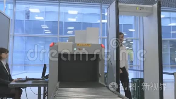英俊的商人在机场用x光扫描仪检查行李