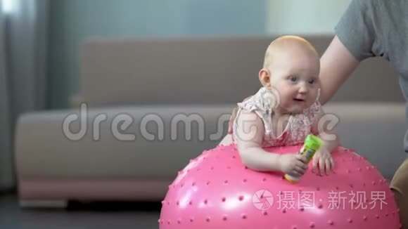 可爱的健康宝宝喜欢在大球上跳跃，为婴儿做健身运动