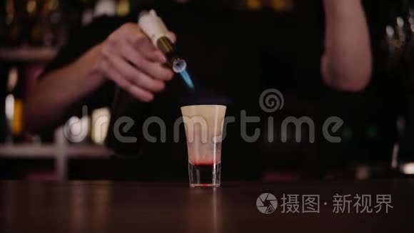 酒保做了一杯火鸡尾酒。 广岛鸡尾酒。 酒吧老板点燃了酒吧里的打火机