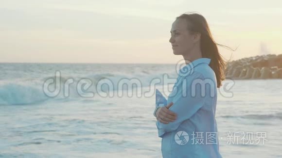 夕阳暖光中看海的年轻女子侧影视频