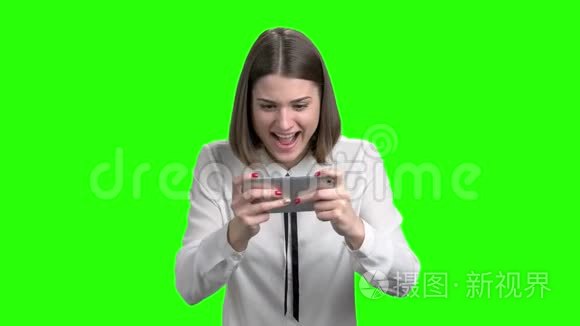 兴奋的女孩在智能手机上玩电子游戏。