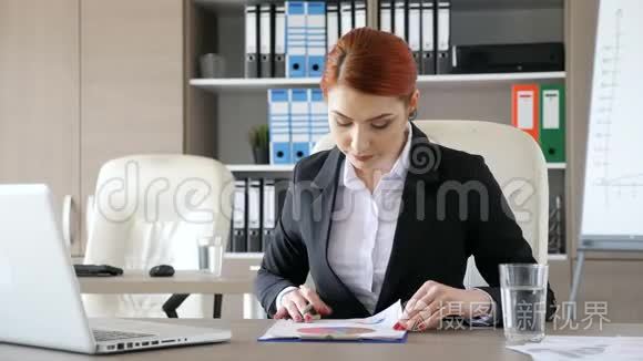 她办公室的女商人签了一些文件