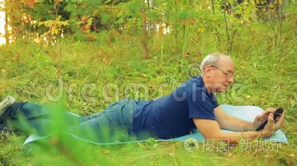 森林里一个戴眼镜的人躺在地毯上，在草地上做瑜伽，用信使传达信息。