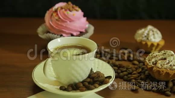 白色杯子里的咖啡，蛋糕和桌子上的咖啡豆
