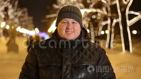 冬天寒冷的夜晚，快乐的男人在户外微笑的肖像