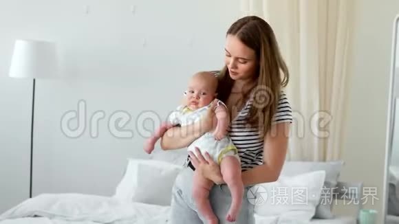 白色公寓中现代年轻家庭的概念.. 妈妈让婴儿上床睡觉，给他唱摇篮曲