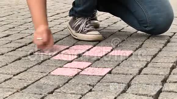 女孩用粉笔在人行道上画画视频