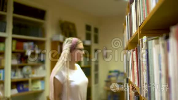 漂亮的女孩在图书馆选了一本书视频