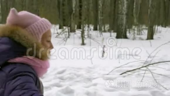 女孩在冬天的森林里跑步，在家庭散步。 森林中的寒假