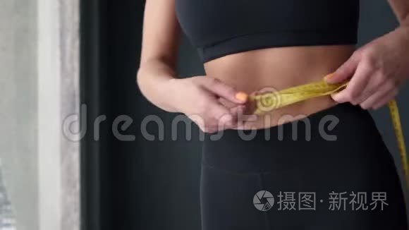 用卷尺量腰的健身妇女视频