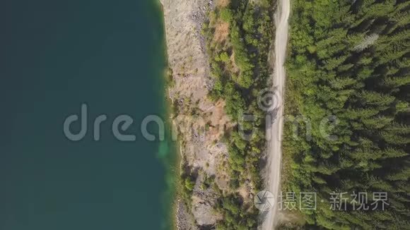 令人惊叹的空中无人机沿湖射击道路。 剪辑。 山景中的池塘和道路