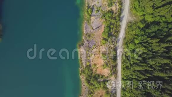 令人惊叹的空中无人机沿湖射击道路。 剪辑。 山景中的池塘和道路