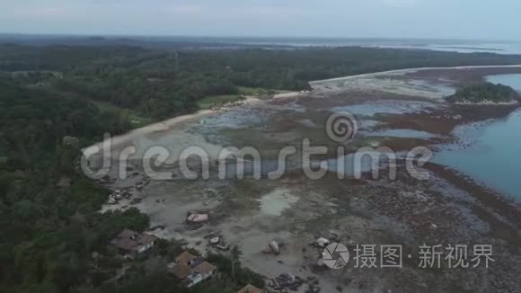 前进的鸟瞰海湾和浅青绿色水域的森林在海洋。 中枪。 在热带上空飞行