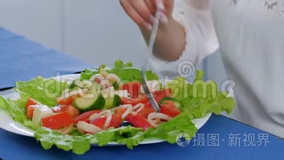 素食，女孩吃桌上盘子里的新鲜沙拉