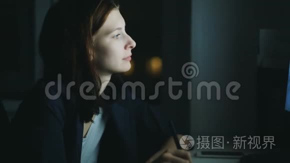 晚上在办公室工作的集中女性设计师使用电脑和图形平板电脑的特写手持镜头