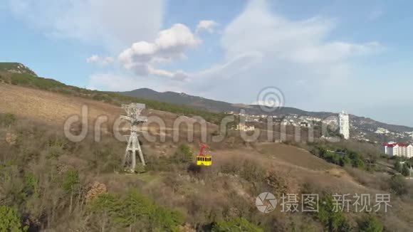 缆车和移动的黄色圆形山丘和建筑物的背景。 中枪。 空中景观