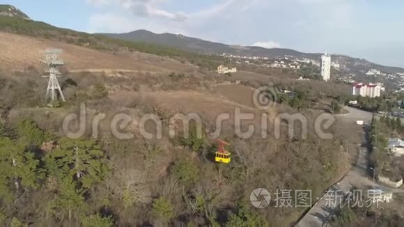 缆车和移动的黄色圆形山丘和建筑物的背景。 中枪。 空中景观