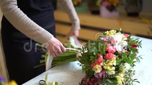 花的组成。粉红色，绿色，洗脸盆，蓝色。美丽的豪华花束在女人的手中。工作