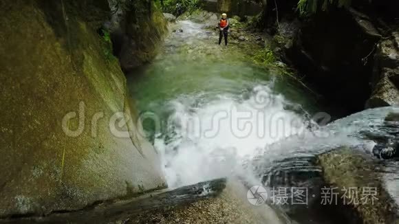 在厄瓜多尔雨林峡谷中，活跃的男子跳入瀑布